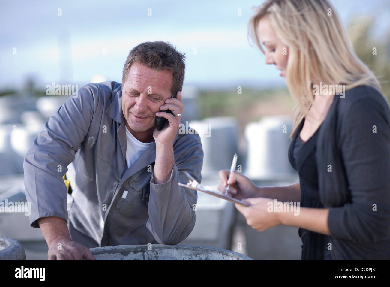 Factory worker talking on cellular phone Banque D'Images