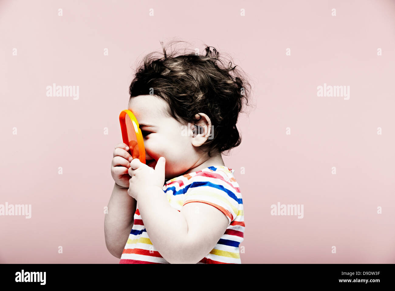 Portrait of baby girl holding plastic toy Banque D'Images