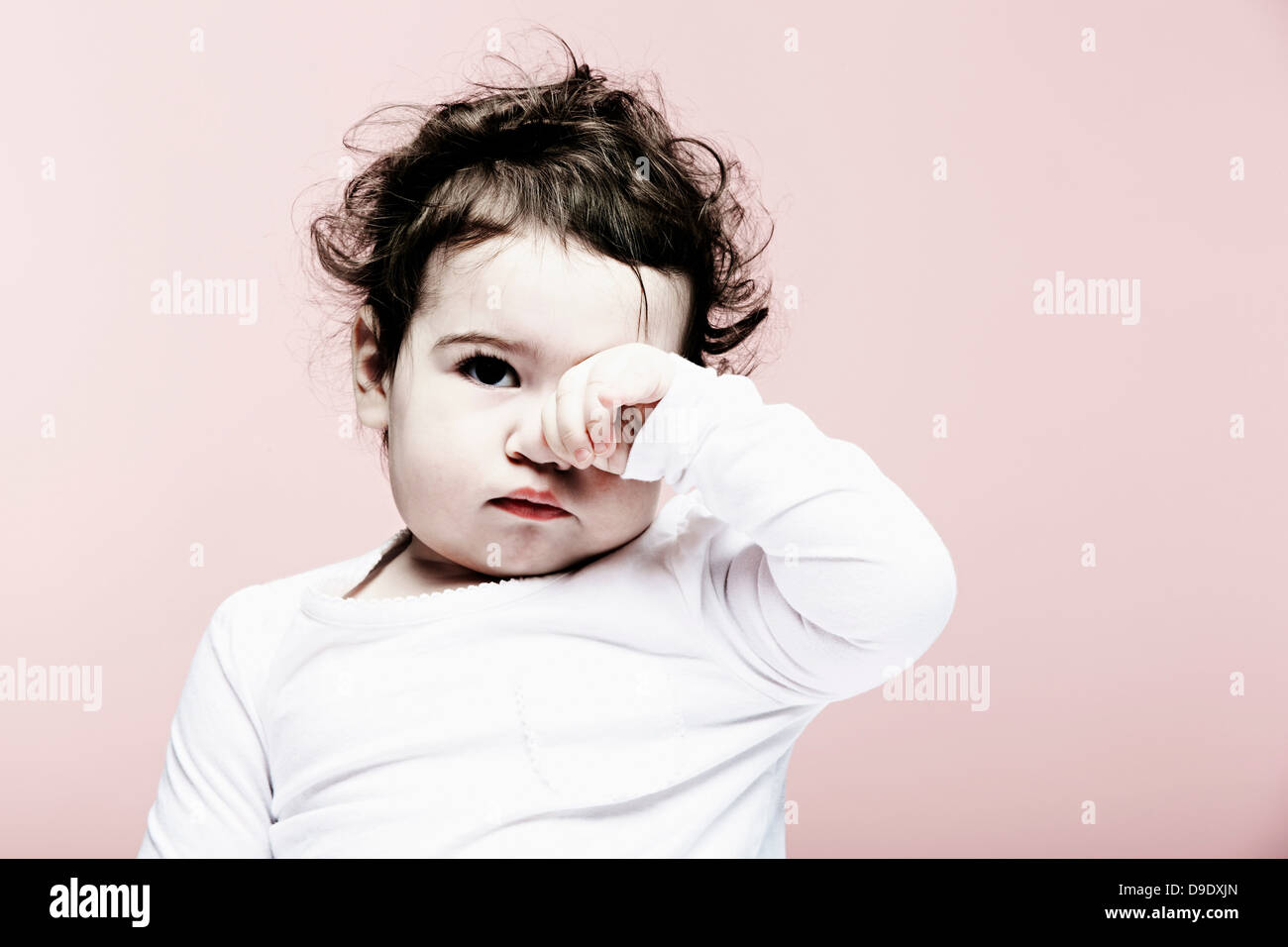 Portrait of baby girl se frottant les yeux Banque D'Images