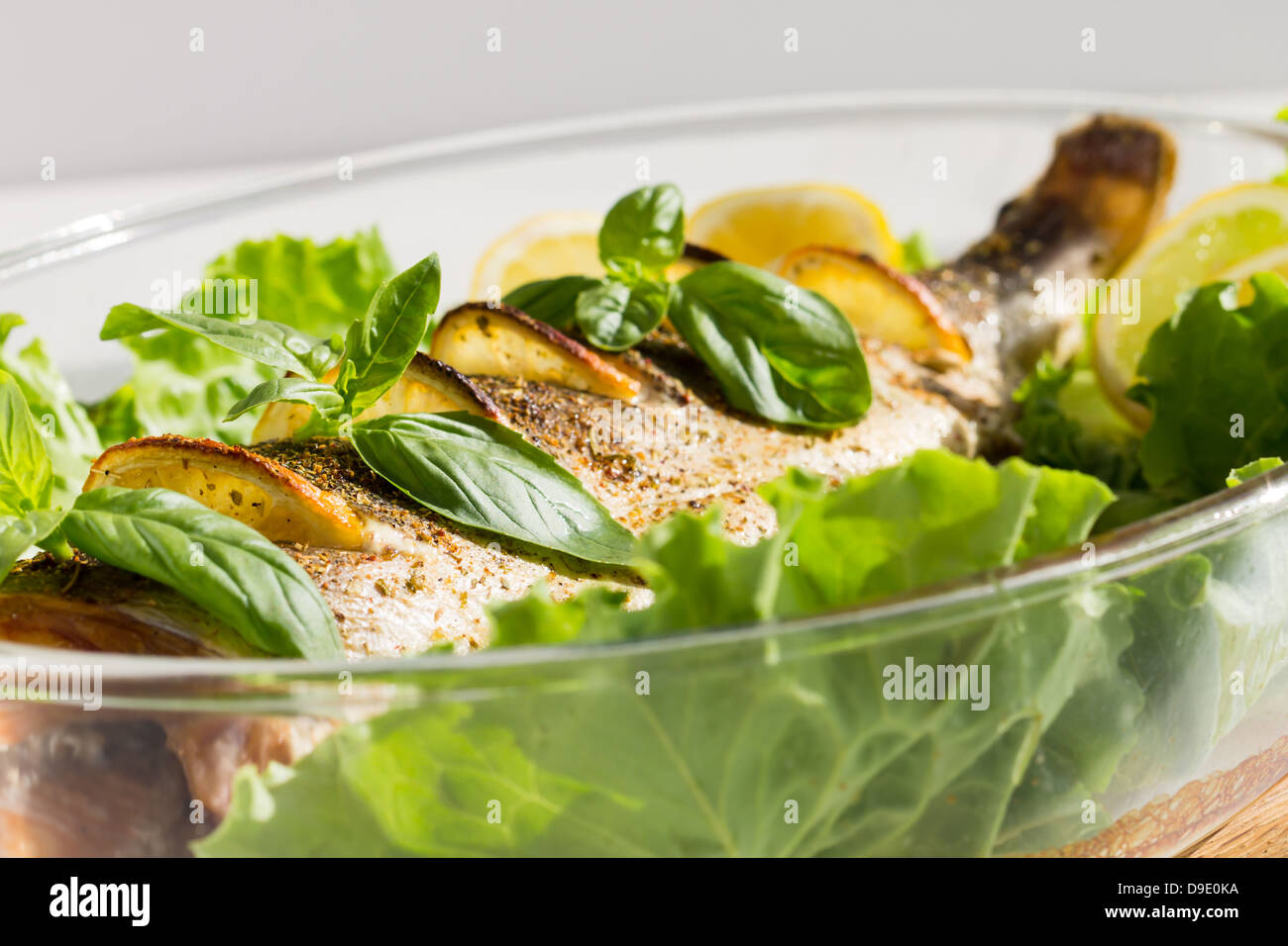 Saumon au four avec du citron, de la salade et le basilic cuit en cocotte  en verre Photo Stock - Alamy