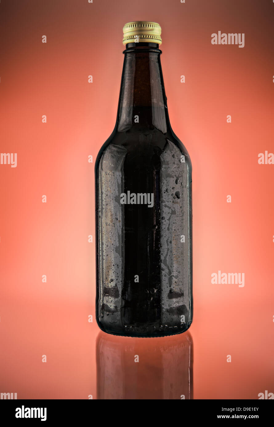 Une bouteille de bière photographié sur un fond rouge lumineux Banque D'Images