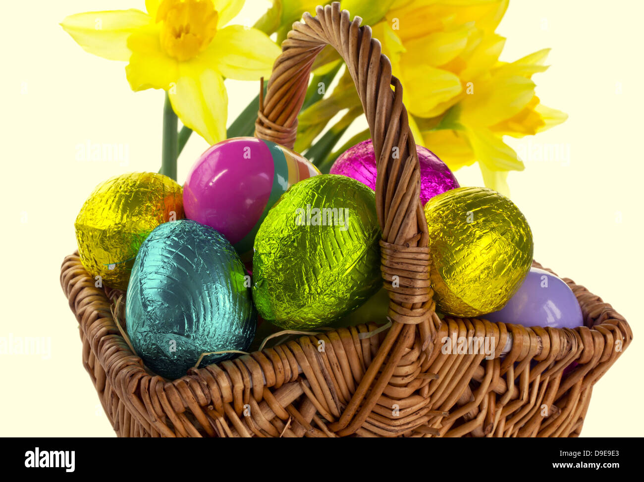 Petit panier en osier avec des oeufs de Pâques et les jonquilles isolé sur  blanc Photo Stock - Alamy