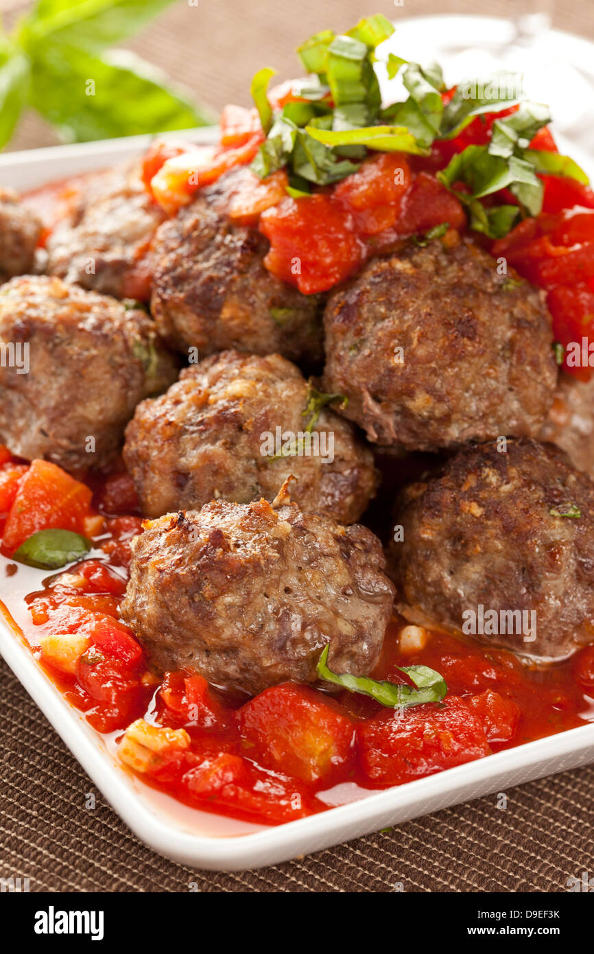 Des boulettes en sauce tomate rouge sur un arrière-plan Banque D'Images