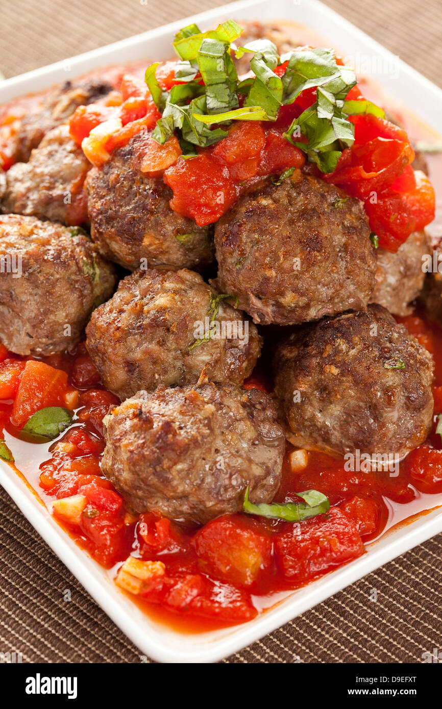 Des boulettes en sauce tomate rouge sur un arrière-plan Banque D'Images