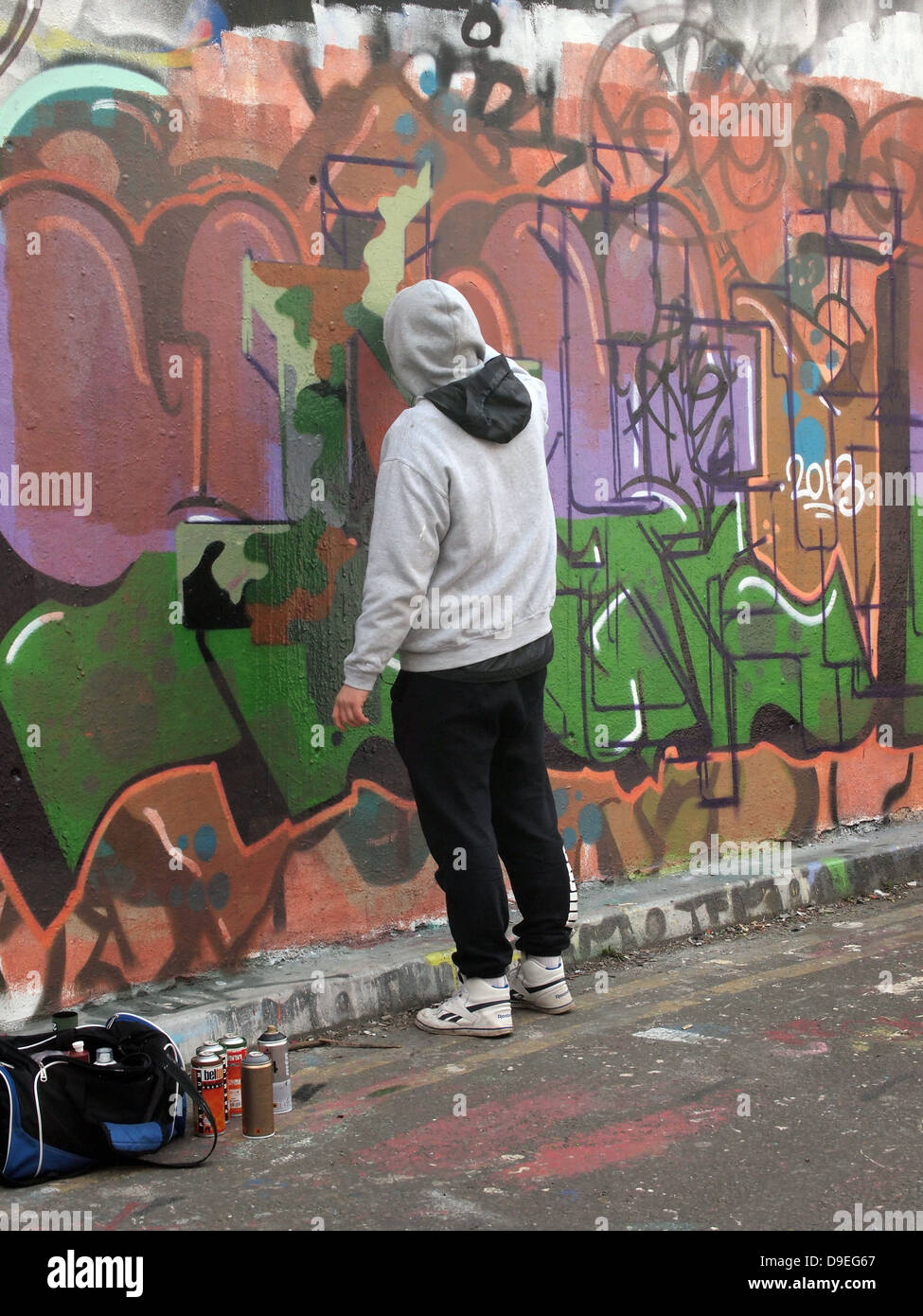 Jeune homme Peinture Graffiti Art dans les zone Graffiti. Banque D'Images