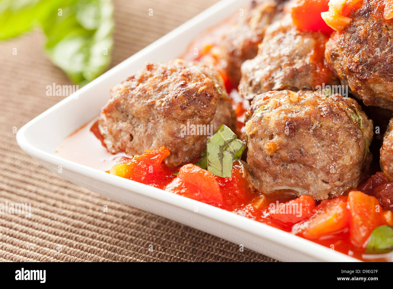 Des boulettes en sauce tomate rouge sur un arrière-plan Banque D'Images
