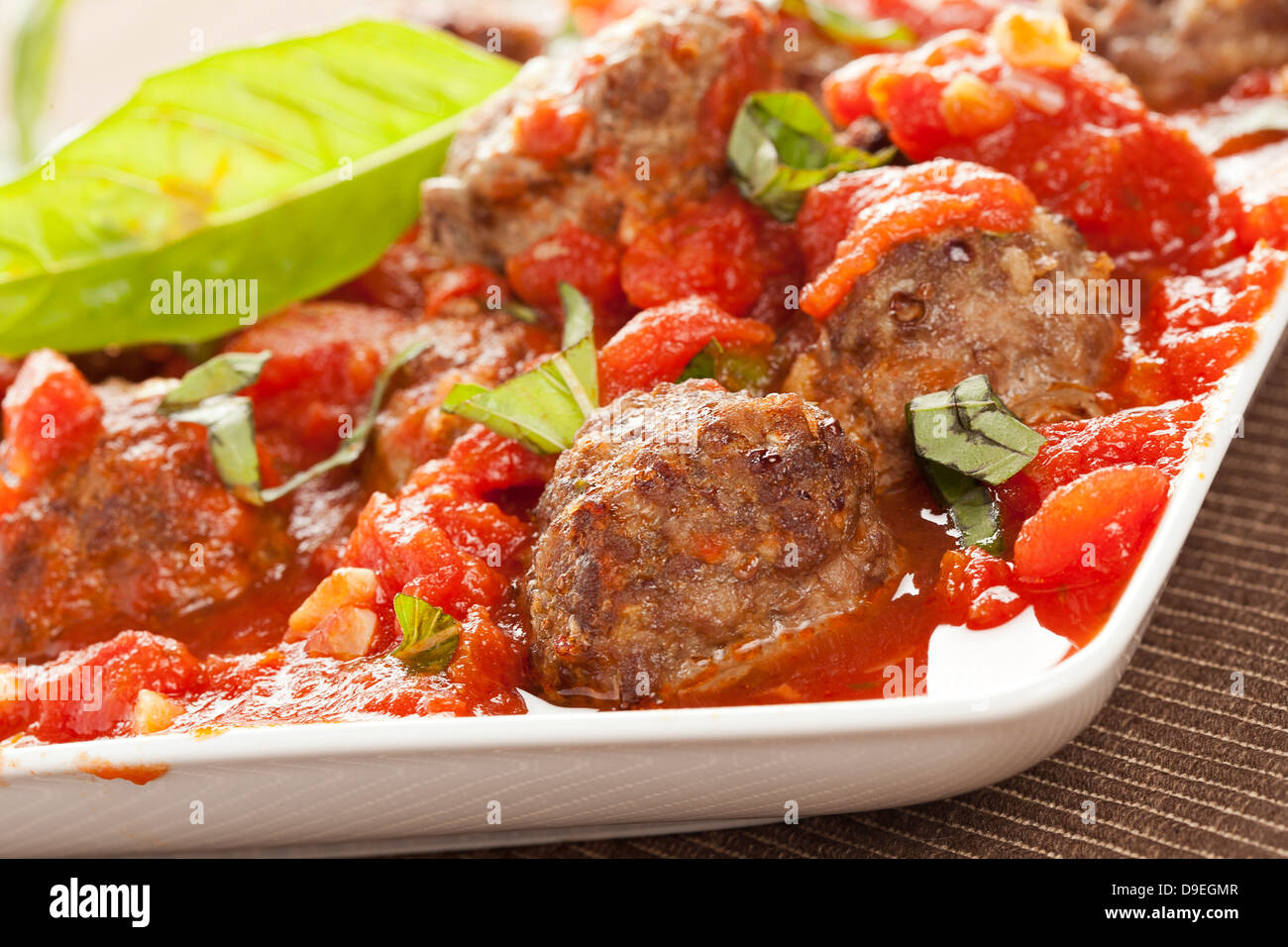 Des boulettes en sauce tomate rouge sur un arrière-plan Banque D'Images