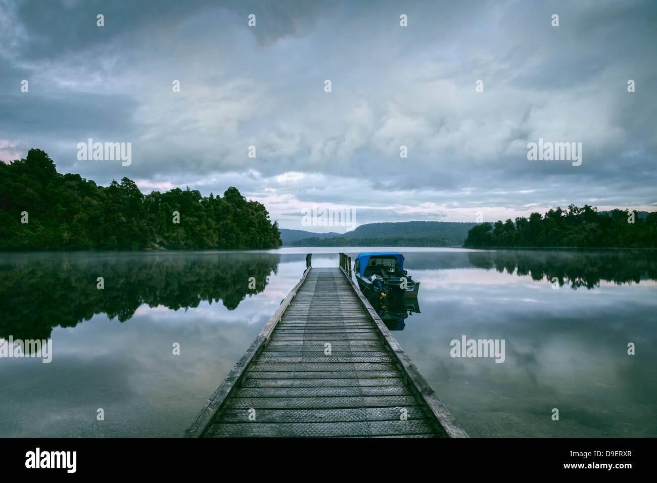 Jetée de pêche et vieux bateau amarré à la fin, le lac Mapourika, sur la côte ouest de l'île Sud de la Nouvelle-Zélande. Banque D'Images