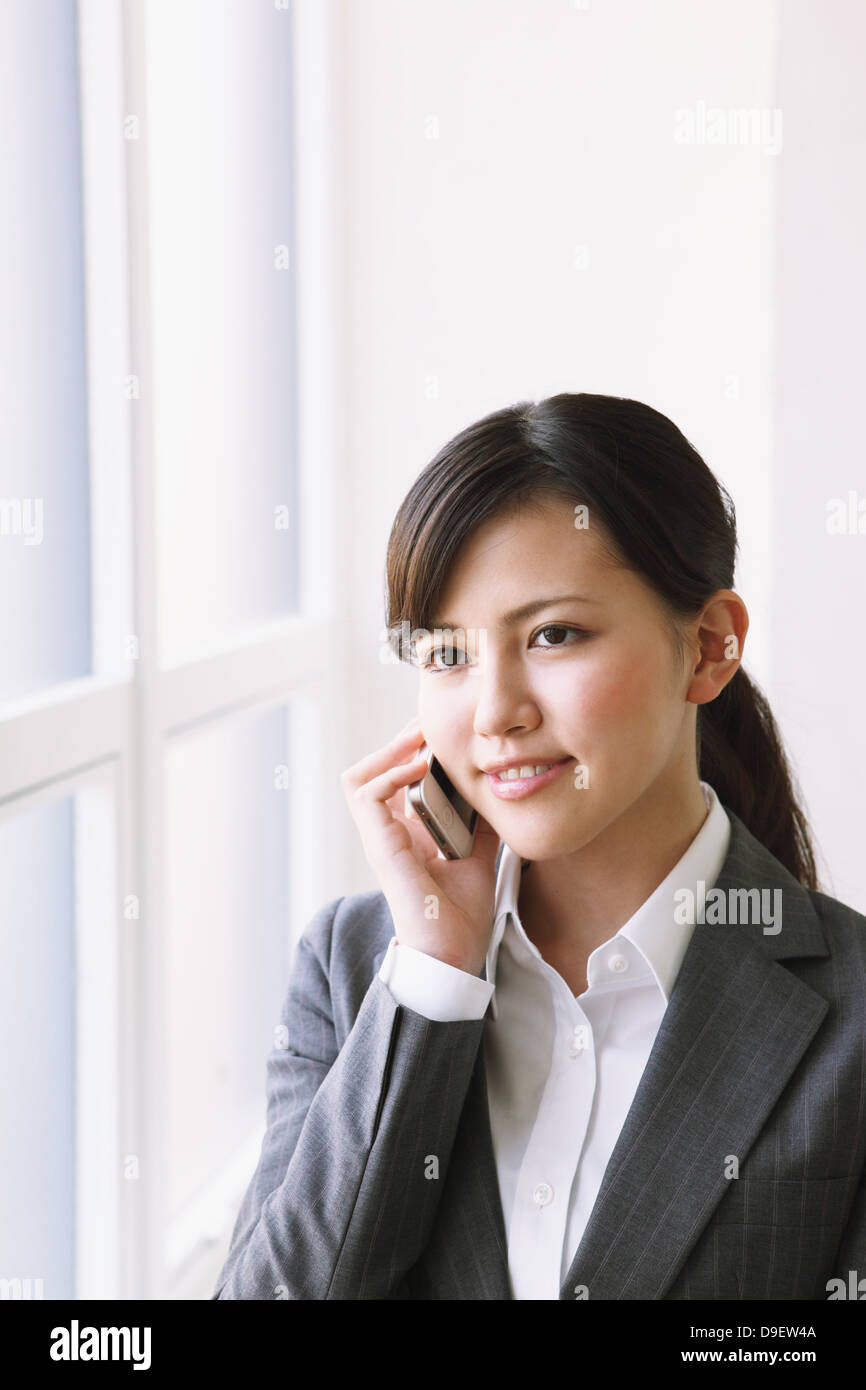 Portrait sur le téléphone par la fenêtre Banque D'Images