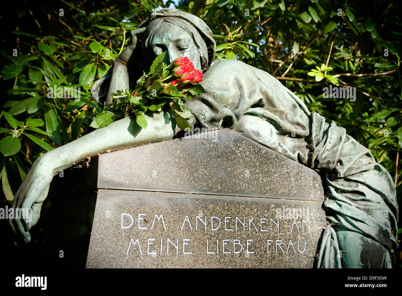 Statue de femme avec des roses sur le cimetière Ohlsdorfer à Hambourg, statue de femme avec des roses sur le village Ohls en cimetière Banque D'Images