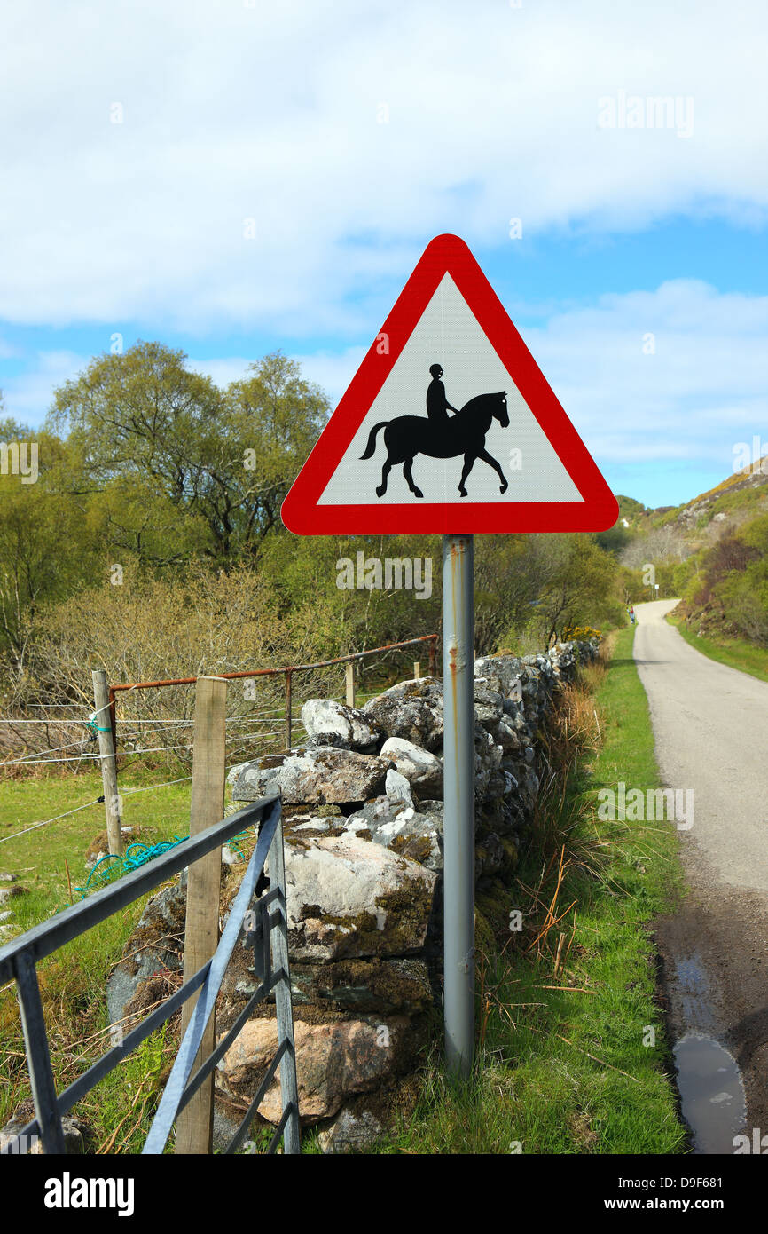 Route de campagne avec panneau d'avertissement pour les conducteurs à être conscients de cavaliers Banque D'Images