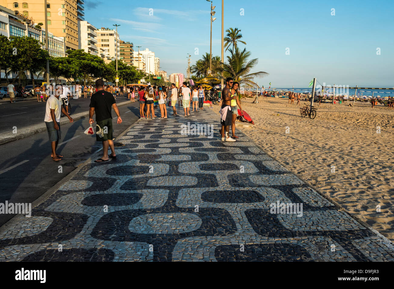 Les gens qui marchent le long du trottoir à la plage d'Ipanema, Rio de Janeiro, Brésil, Amérique du Sud Banque D'Images