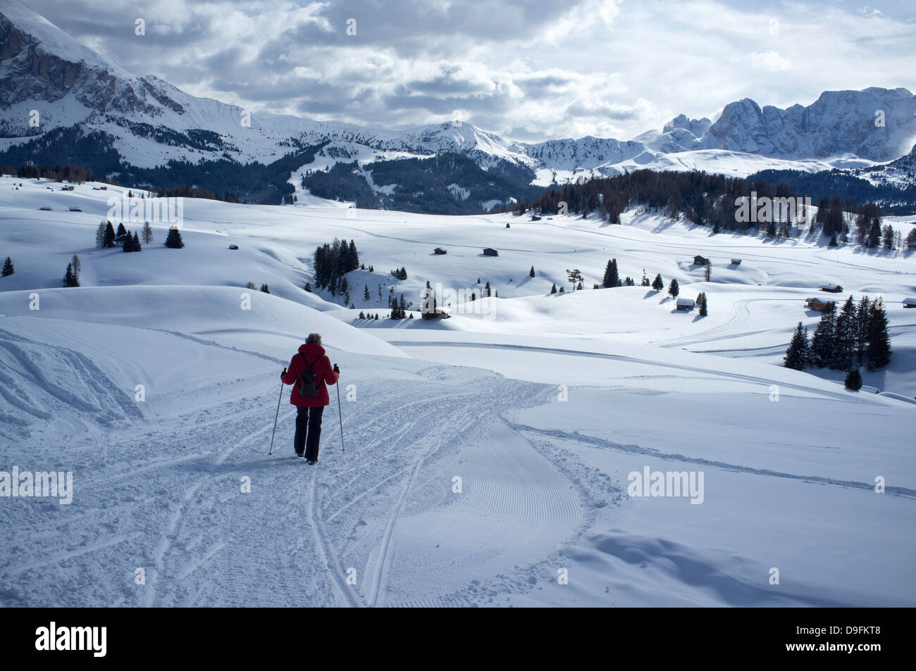 Une femme marche sur un sentier de neige à l'Alpe di Siusi Ski près de la ville d'Otisei dans les Dolomites, le Tyrol du Sud, Italie Banque D'Images