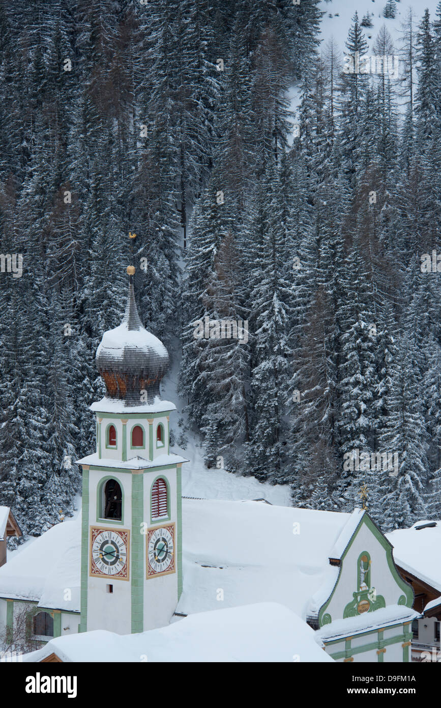 L'église de San Cassiano et derrière les arbres couverts de neige, San Cassiano, Dolomites, Tyrol du Sud, Italie Banque D'Images