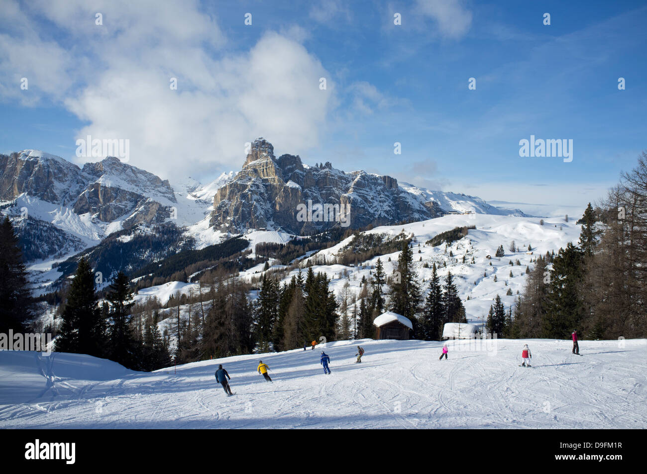 Skieurs de la station de ski Alta Badia avec Sassongher Mountain dans la distance, Dolomites, Tyrol du Sud, Italie Banque D'Images