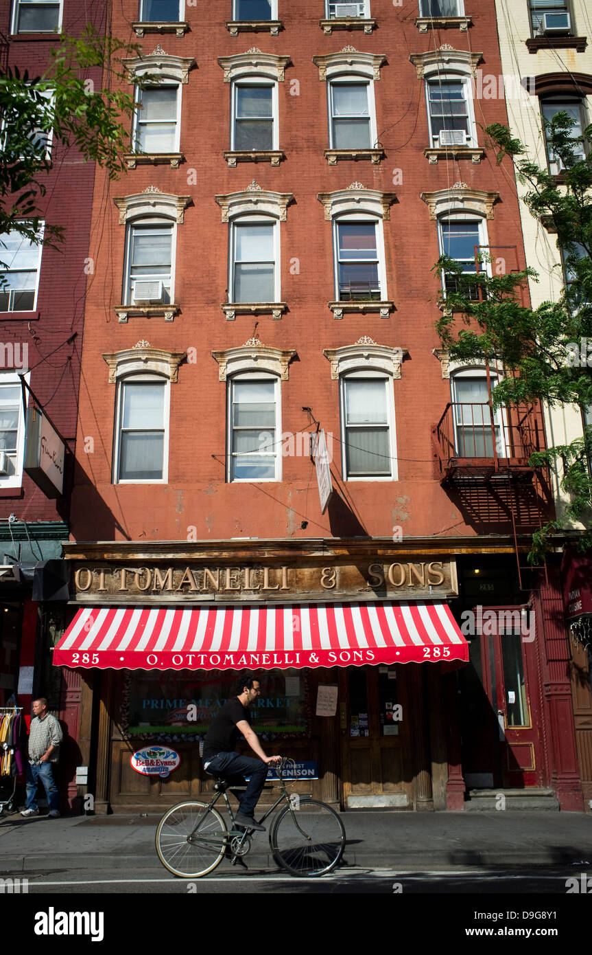 La Bleecker Street, Greenwich Village, New York City. Façade, bâtiment, moto, vélo, cheval, cavalier, équitation, parasol Banque D'Images