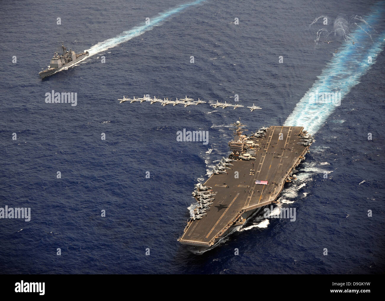 F/A-18 Hornet voler en formation au porte-avions USS Abraham Lincoln et USS Cape St. George. Banque D'Images
