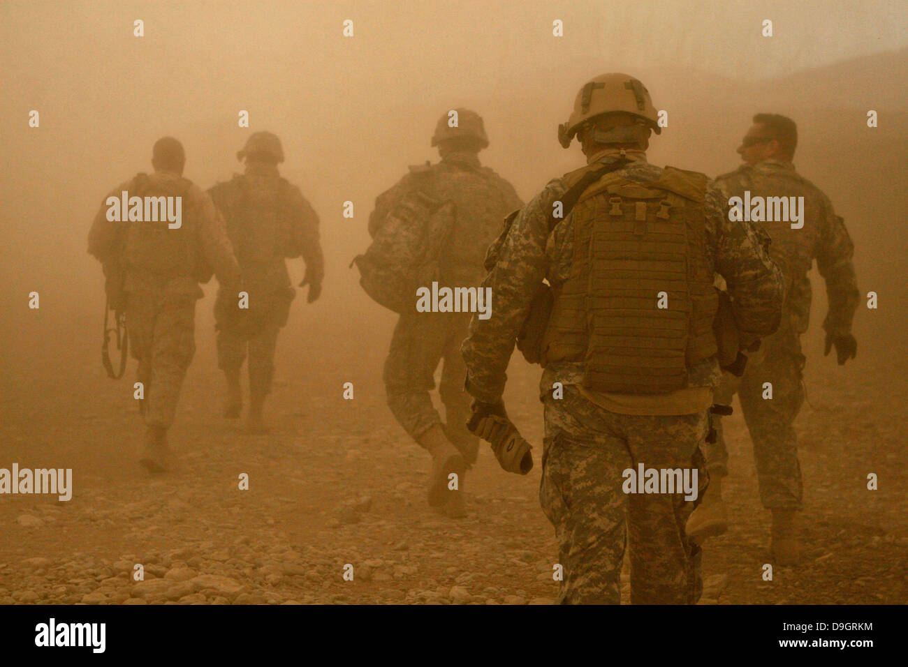 Les soldats américains et marines à pied à travers la poussière créée par le souffle du rotor d'un hélicoptère UH-60 Black Hawk lors d'opérations le 5 janvier 2011 à Darrah-I-Bum, province de Badghis, l'Afghanistan, le 5 janvier 2011. Banque D'Images