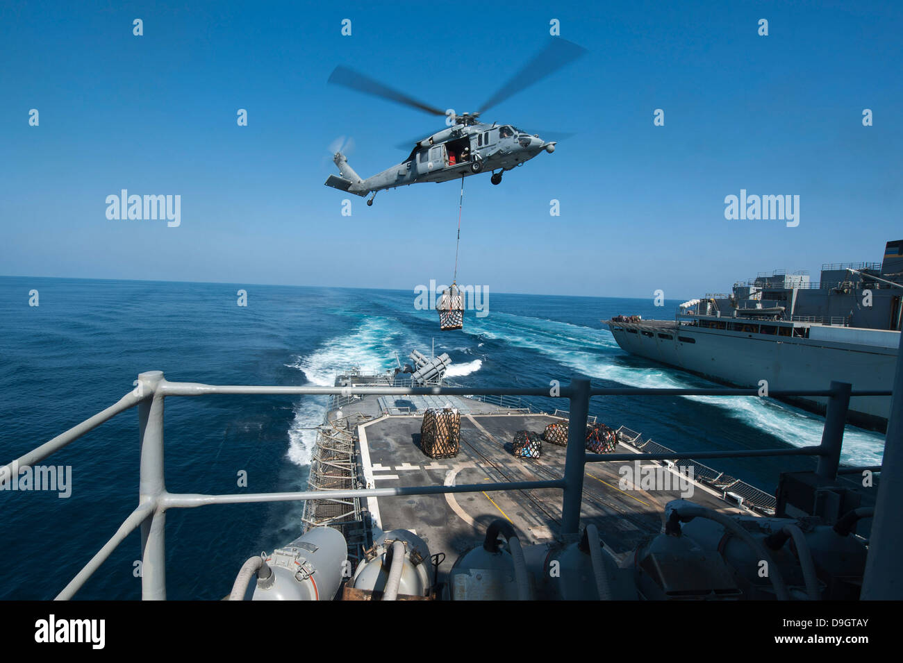 Un MH-60S Sea Hawk apporte des palettes de fournitures à USS Mobile Bay. Banque D'Images