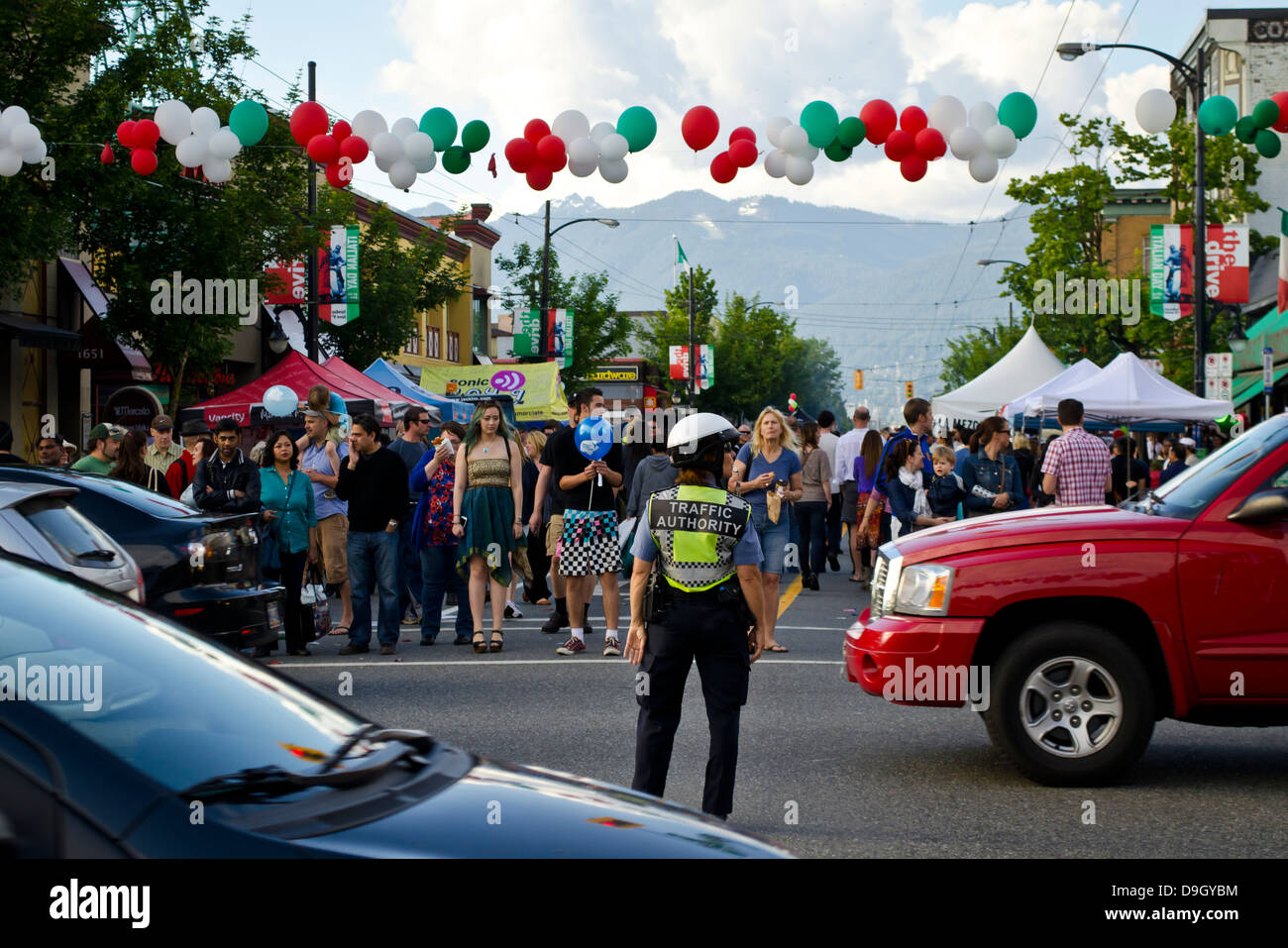 Un agent de la circulation à grande circulation contrôles alors que la foule attend pour traverser la rue à jour italien festival de rue dans l'Est de Vancouver. Banque D'Images