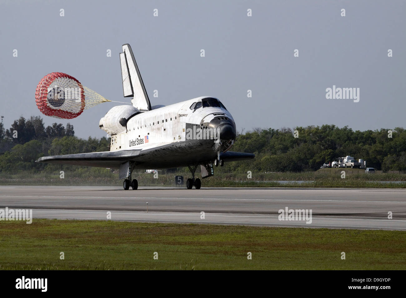 Faites glisser avec abattant déployé, la navette spatiale Discovery atterrit sur la piste 33 à l'Atterrissage au Centre spatial Kennedy en Banque D'Images
