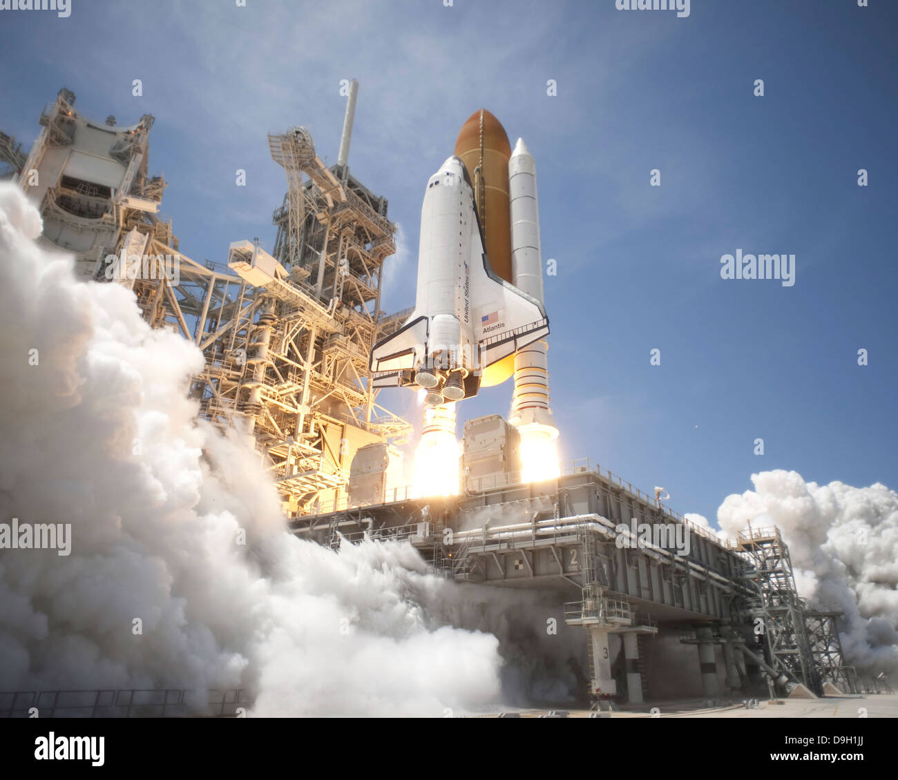Un panache d'échappement formulaires conformément à la plate-forme de lancement mobile sur la plateforme de lancement 39A, comme la navette spatiale Atlantis décollera en orbite. Banque D'Images