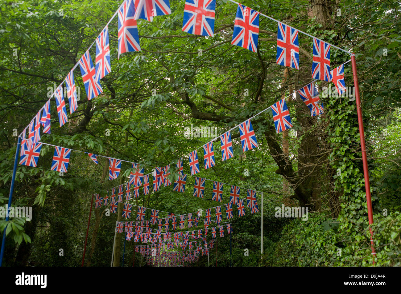 Des centaines d'union jack flag bunting remonte la pente à travers bois vers le poste local pendant le festival annuel de Royal Ascot hippodrome dans le Berkshire, en Angleterre. Royal Ascot est l'une des plus célèbres courses, et remonte à 1711. La reine Elizabeth et divers membres de la famille royale britannique. Tenue chaque année au mois de juin, c'est l'une des principales dates du calendrier sportif anglais et en été, des saisons. Plus de 300 000 personnes font la visite annuelle à Berkshire Ascot Royal pendant la semaine, ce qui en fait l'Europe's best-assisté réunion de courses avec plus de £3m prix en argent à gagner. Banque D'Images
