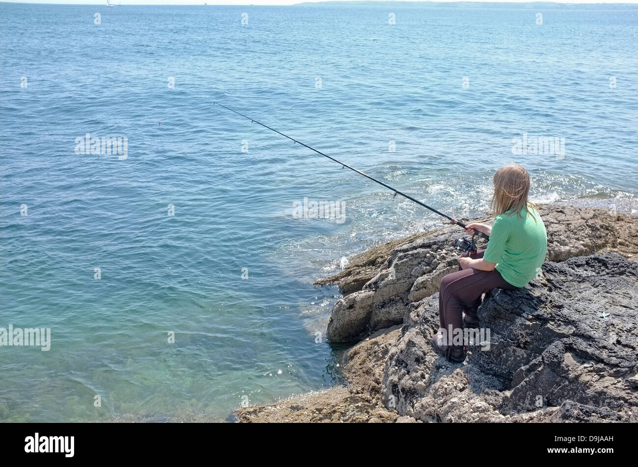A 10 ans, fille de poissons les rochers au point de Pendennis à Falmouth, Cornwall, UK Banque D'Images