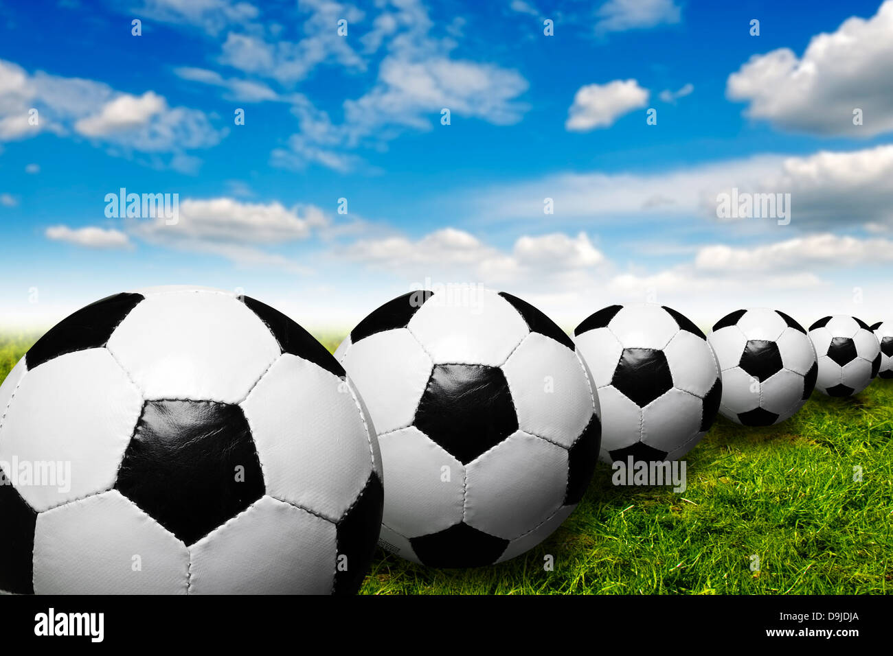 Les ballons de football dans une rangée Banque D'Images