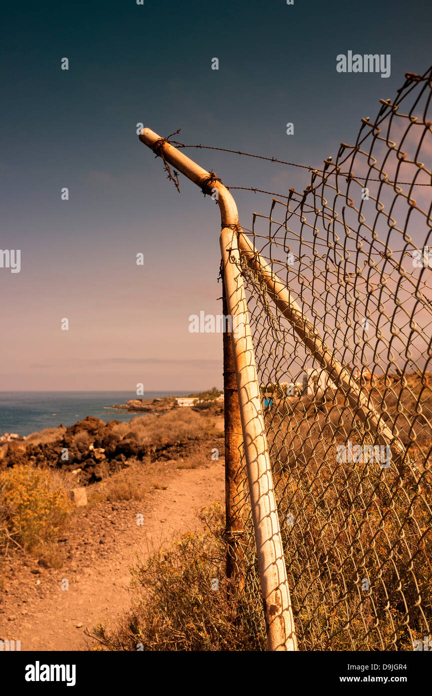 Le montant d'angle de grillage de clôture avec dont les brins de fil de fer barbelé au-dessus, sur la côte, près de Alcala, Tenerife, Îles Canaries Banque D'Images