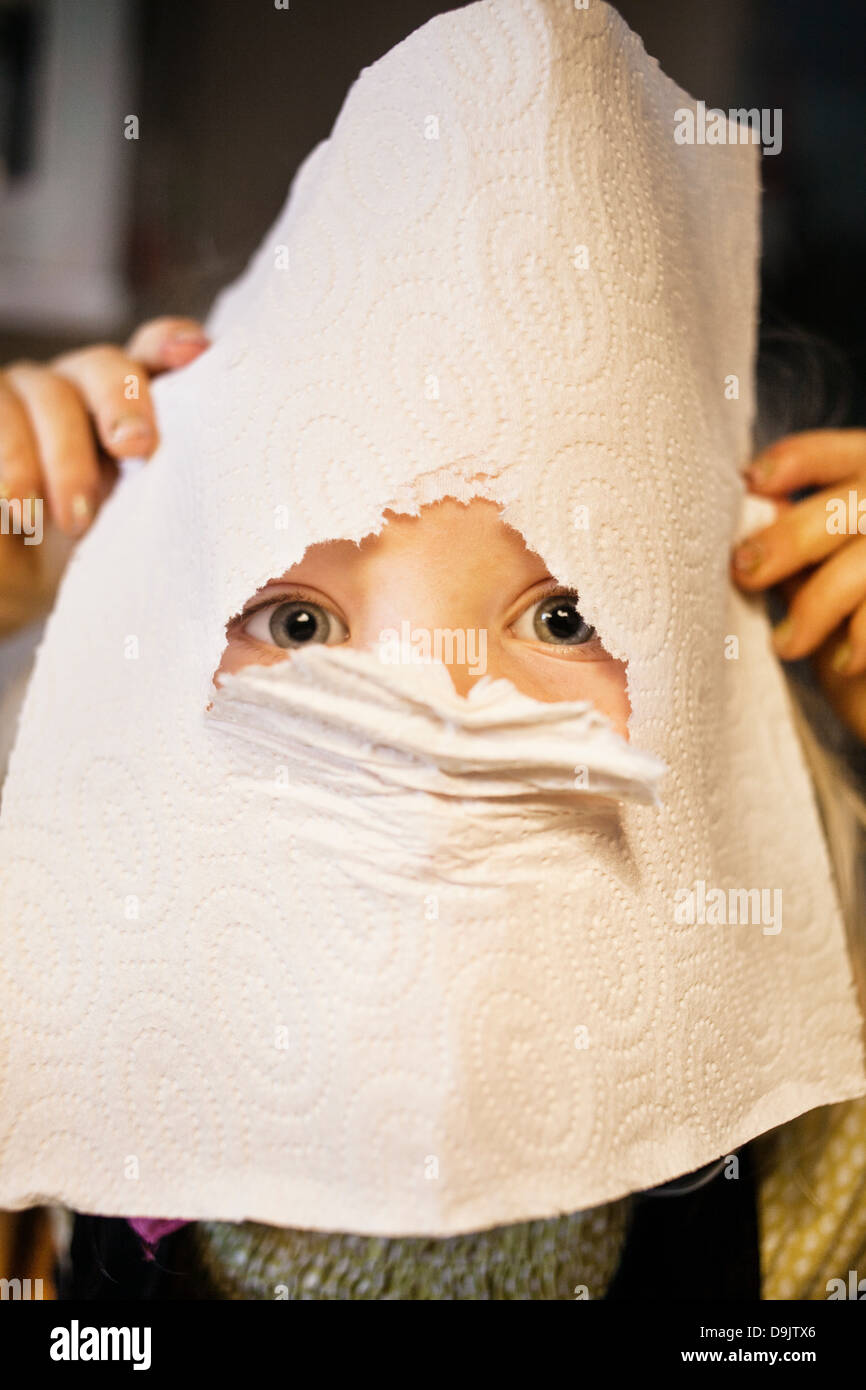 Portrait de jeune fille à travers le trou dans la serviette de cuisine Banque D'Images
