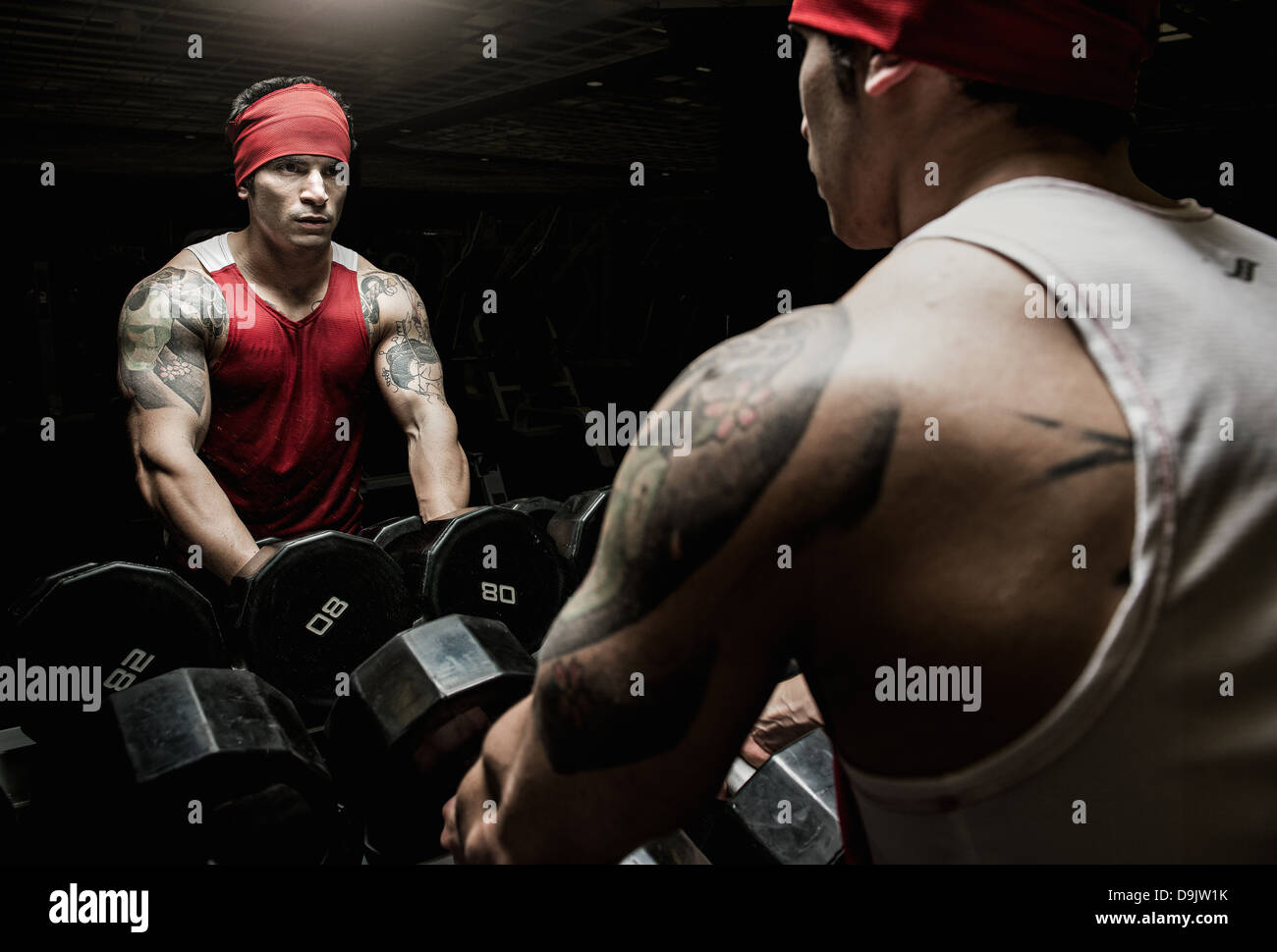 Jeune homme musclé à la salle de sport en miroir Banque D'Images