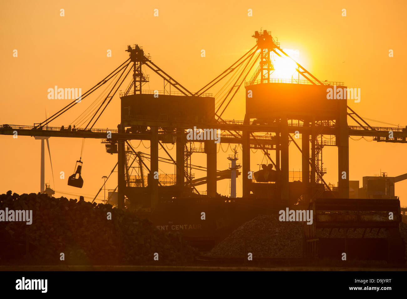 Le charbon importé de grues à la Tata Steel works à Ijmuiden Pays-bas, au coucher du soleil. Banque D'Images