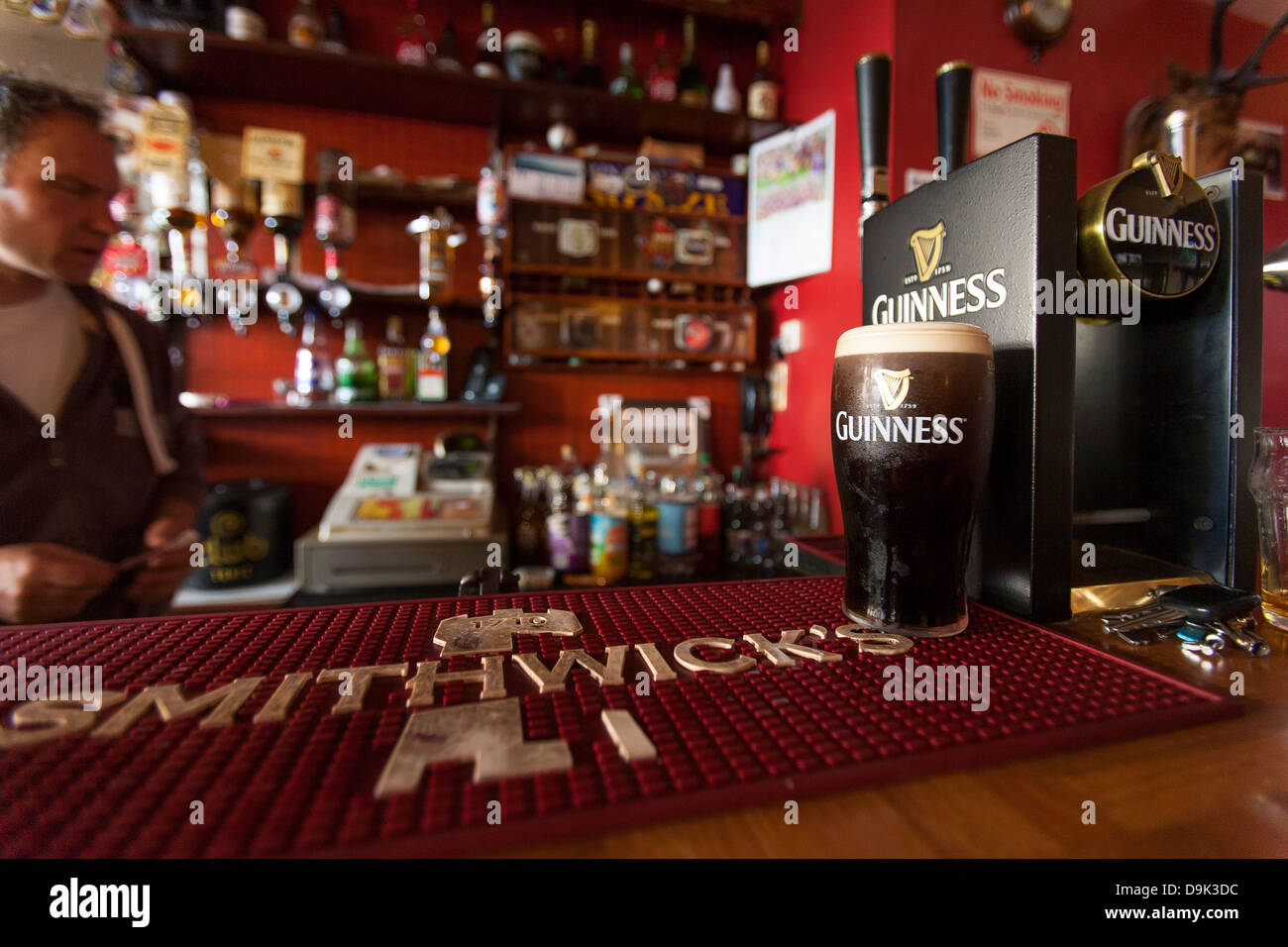 Un barman sert une Guinness dans un des nombreux pubs Kenmares dans lecentre de Kenmare, dans la République d'Irlande. Banque D'Images
