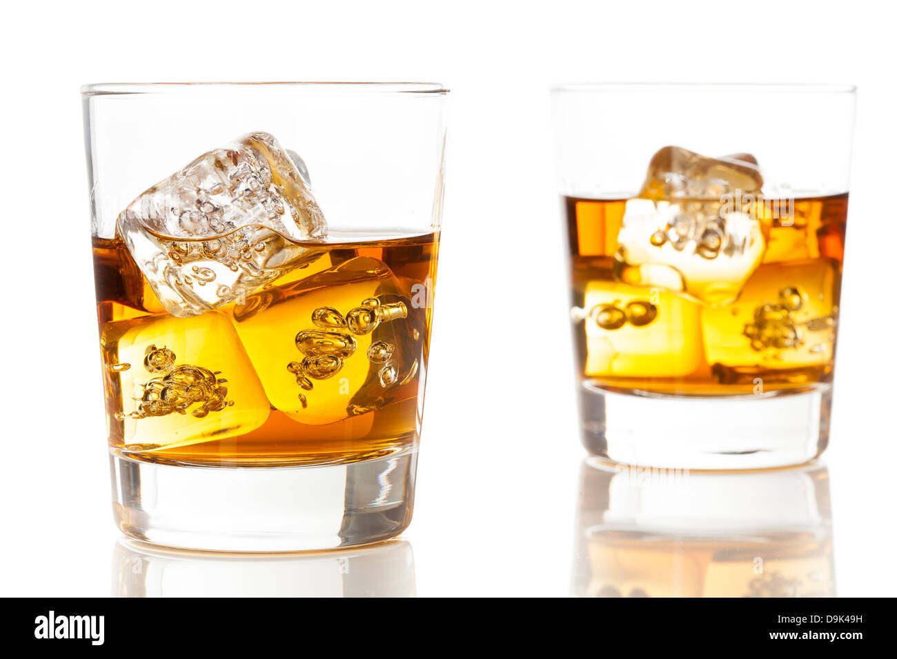 Whisky brun doré sur les rochers dans un verre Banque D'Images