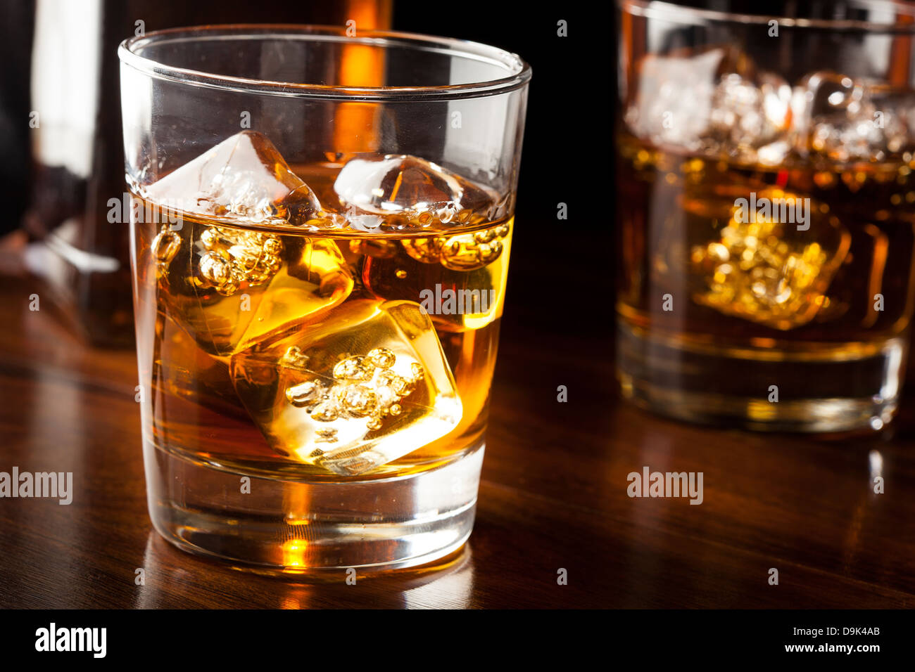 Whisky brun doré sur les rochers dans un verre Banque D'Images