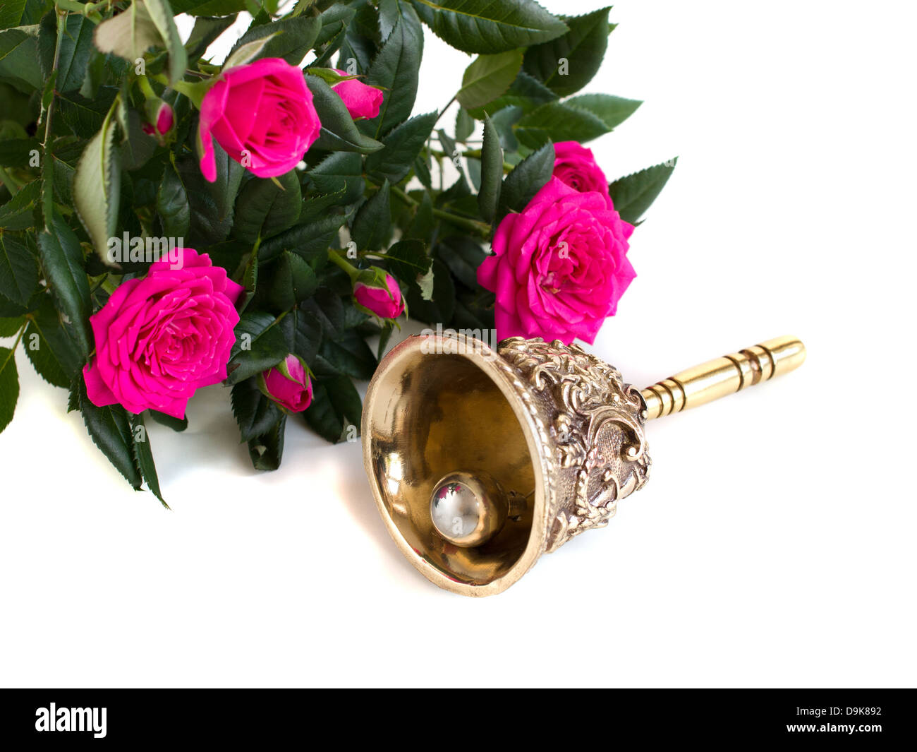 Cloche en bronze antique et le bouquet de roses sur un fond blanc Banque D'Images