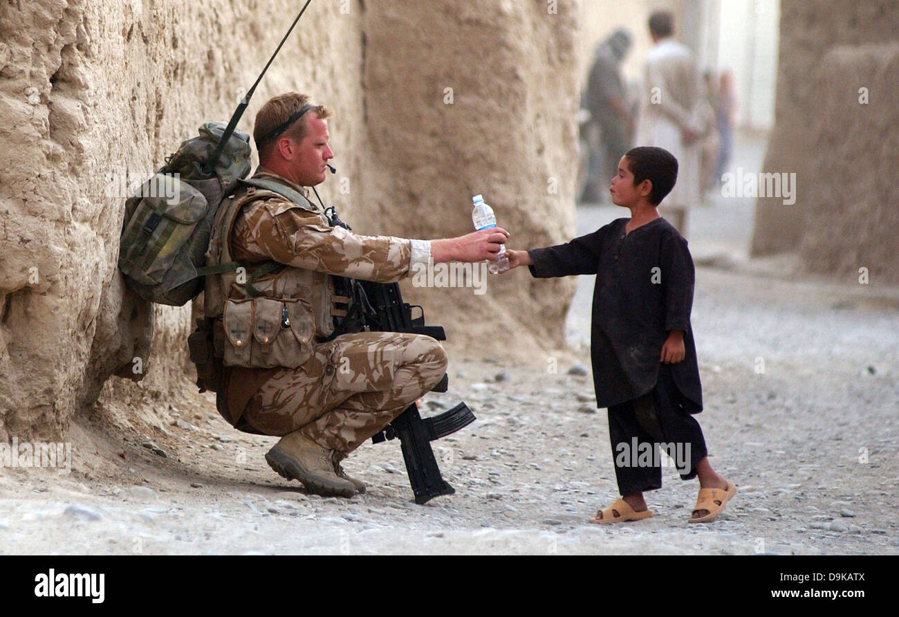 Aviateur de la Royal Air Force britannique Joe Ralph mains une bouteille d'eau pour un enfant de la région au cours d'une patrouille de la Force internationale d'assistance à la sécurité, 19 juillet 2008 dans la province de Kandahar, Afghanistan. Les patrouilles de routine de la RAF les environs de Kandahar, pour empêcher les attaques de roquettes à la base. Banque D'Images