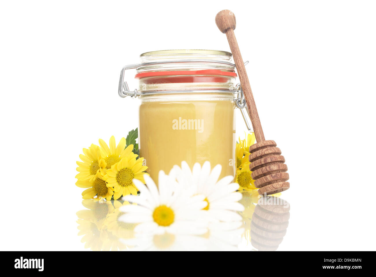 Verre de miel avec une cuillère de miel et de fleurs, pot de miel avec une cuillère de miel et de fleurs Banque D'Images