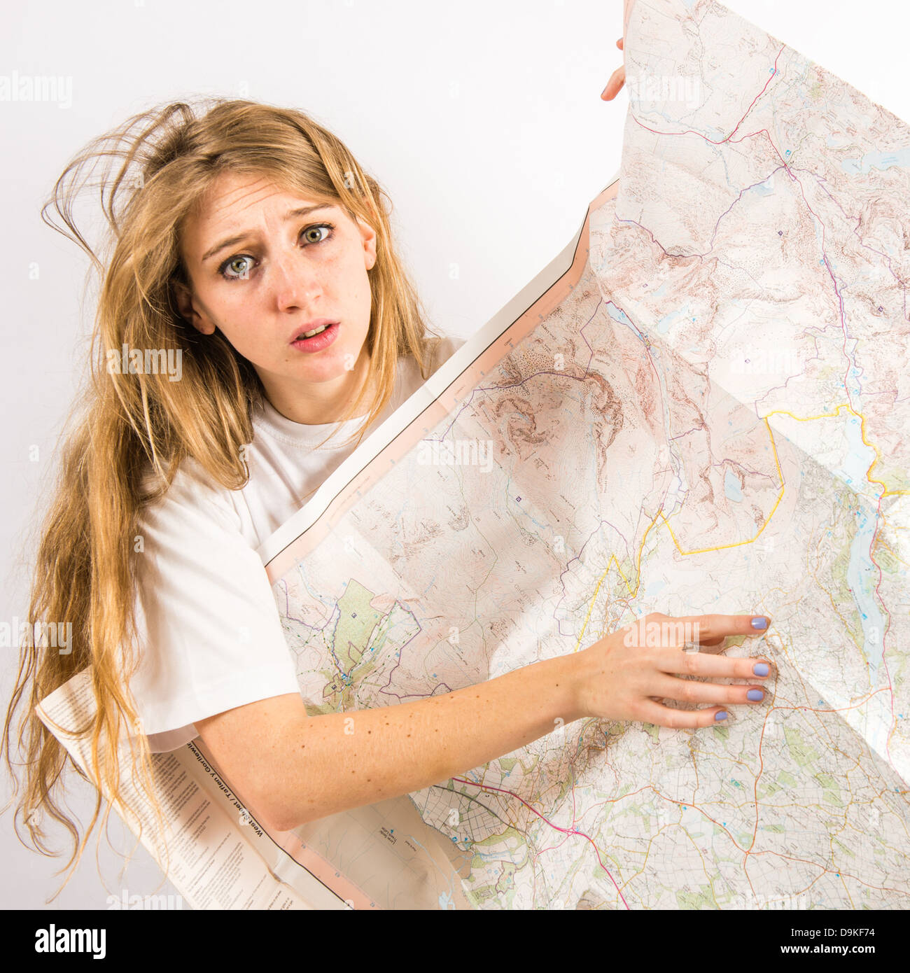 Un jeune femme avec de longs cheveux blonds à perdu et inquiet la tenue d'une carte de l'Ordnance Survey, UK Banque D'Images