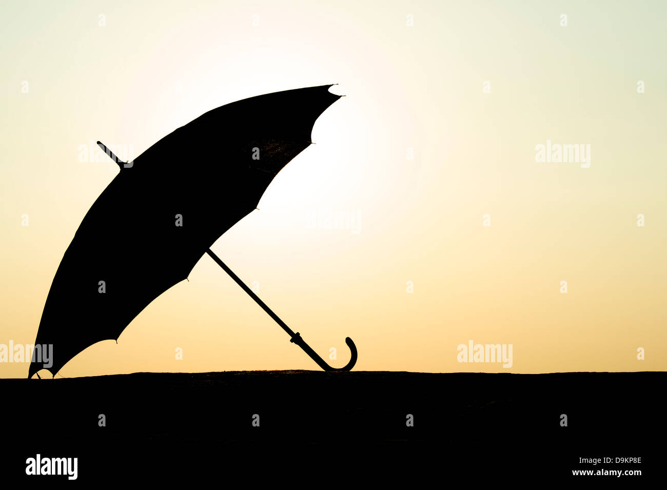 Silhouette parapluie au coucher du soleil Banque D'Images