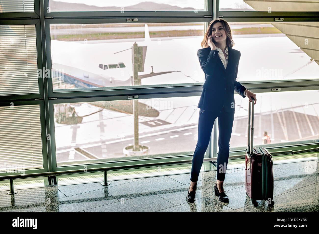 Young woman on cell phone in airport Banque D'Images