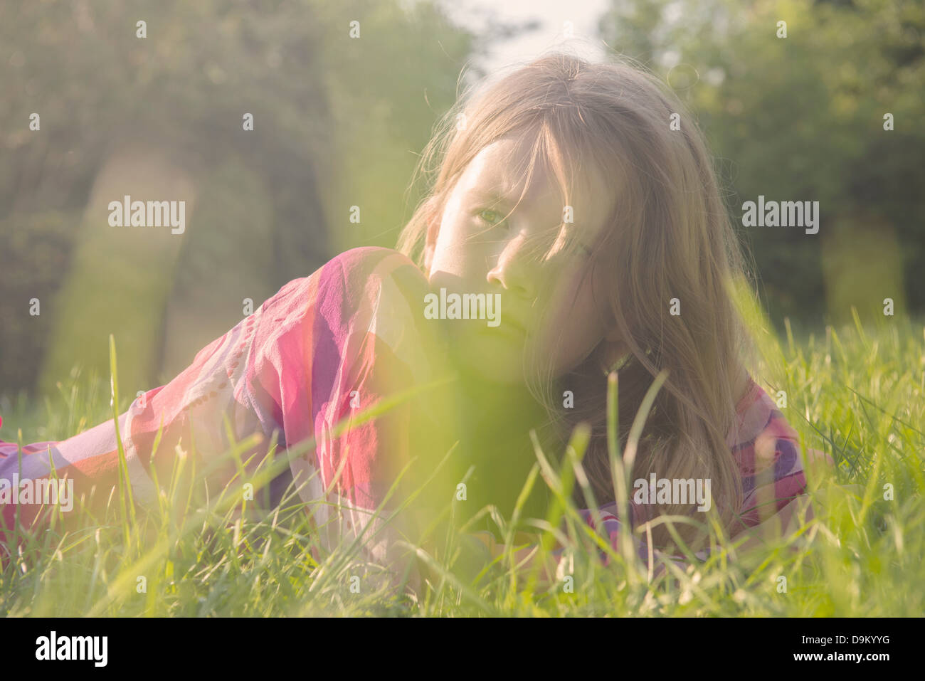Girl couché dans le champ en été Banque D'Images