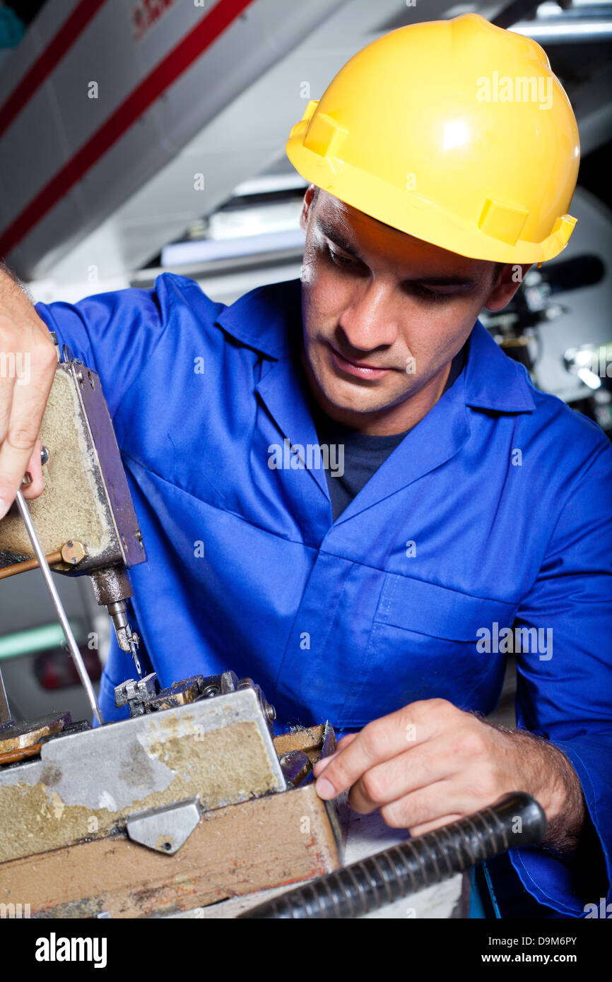 Homme mechanic repairing industrial sewing machine Banque D'Images