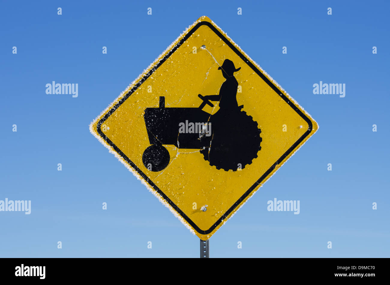 Frosty agriculteur agriculteur signe avec sur un tracteur sur un matin froid avec fond de ciel bleu Banque D'Images