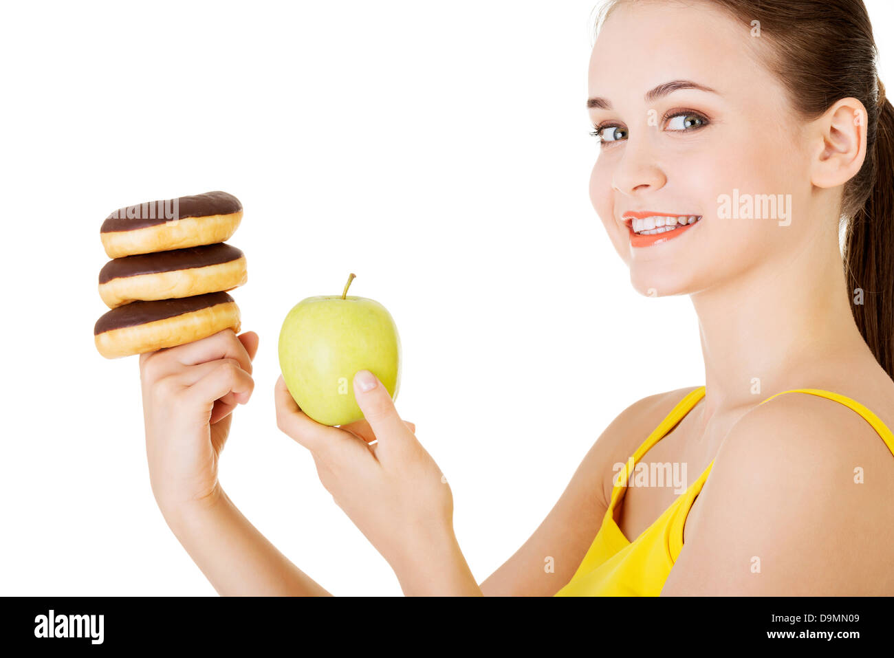 Donut ou pomme verte - choix difficile. Concept de régime. Banque D'Images