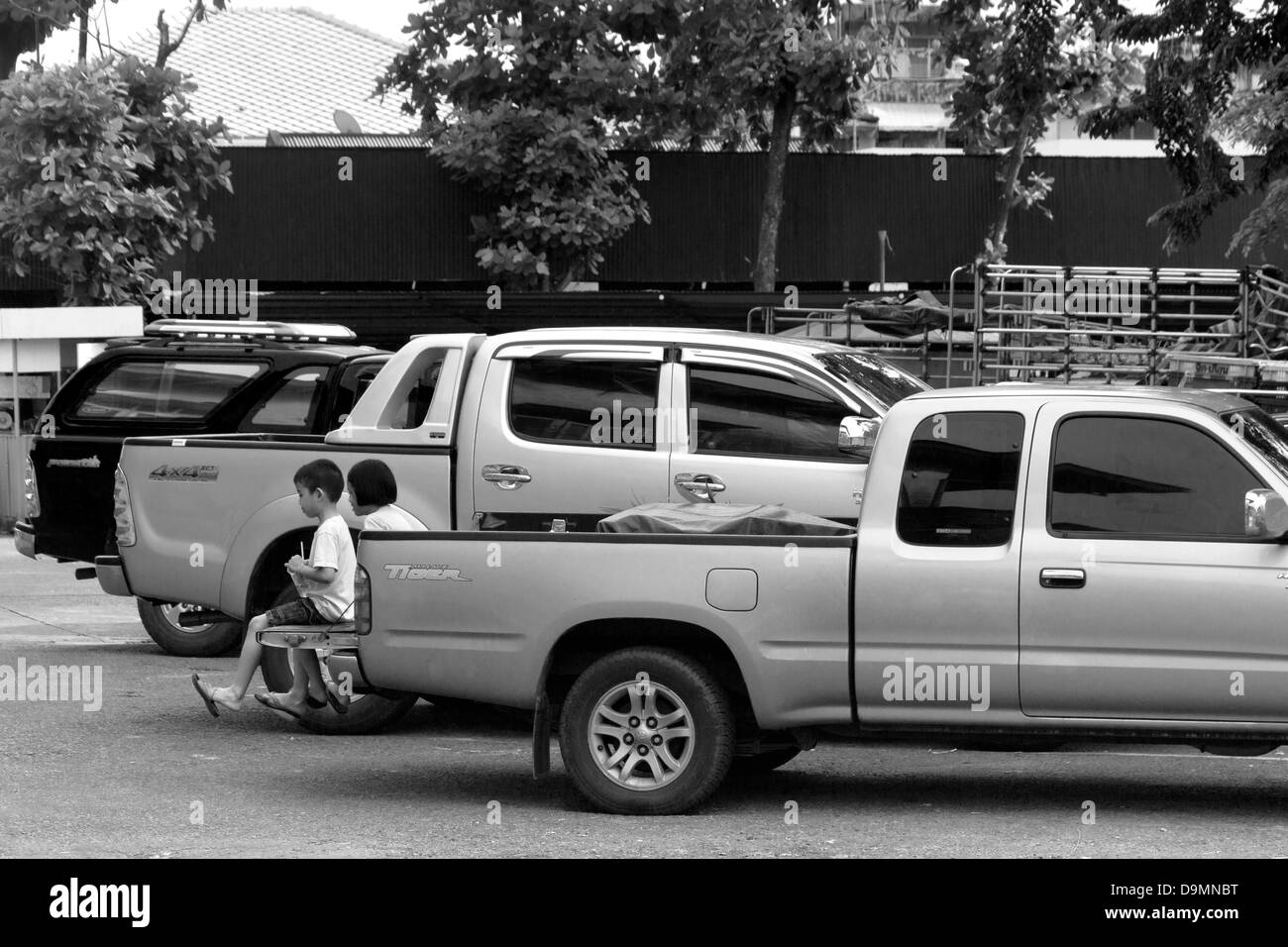 Marché du centre ville, la ville de Phuket, Phuket, Thaïlande : 12 septembre 2012 : Deux enfants assis à l'arrière du camion pick-up Banque D'Images