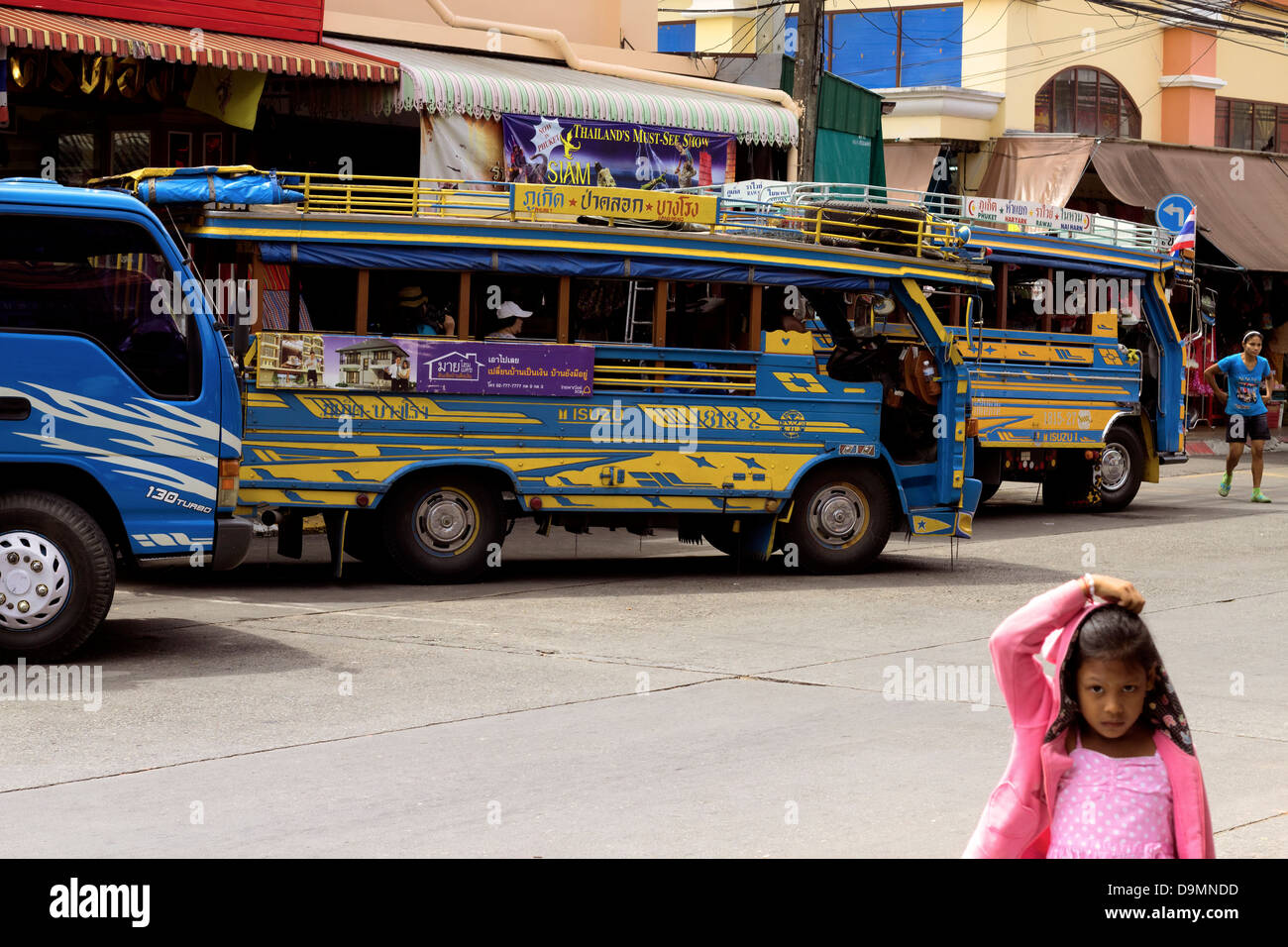 La ville de Phuket, Phuket, Thaïlande le 2 novembre 2012 : un enfant se place en avant des autobus en attente de dépôt de bus au départ Banque D'Images