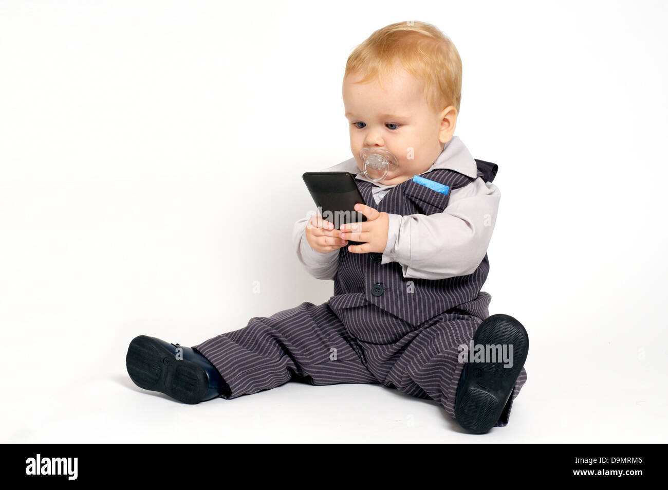 Blond bébé en fonction des sms avec un téléphone mobile Banque D'Images