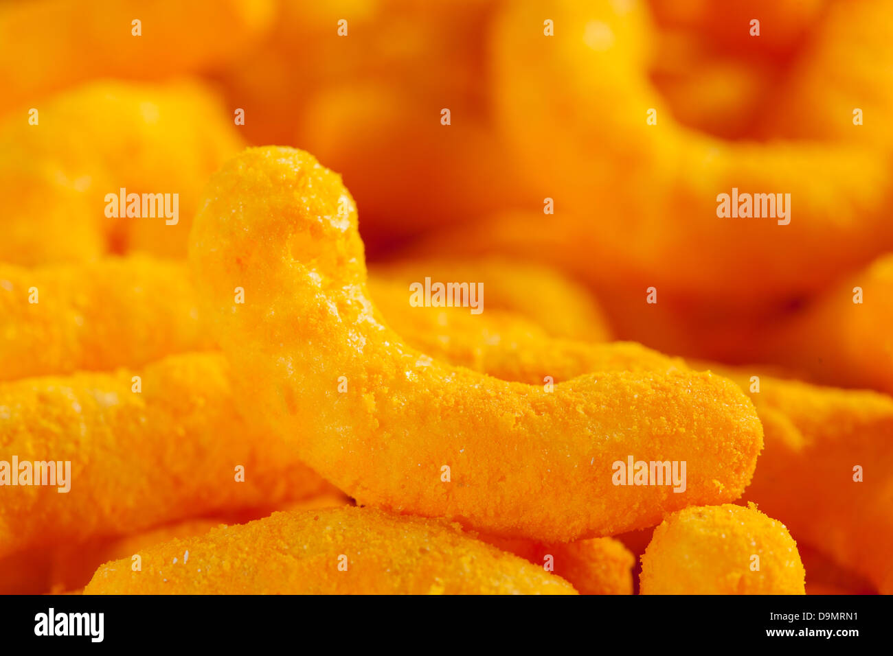 Chips Fromage Puffy Orange malsaine contre un arrière-plan Banque D'Images
